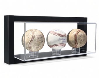 May include: A black rectangular display case with a clear acrylic front containing three white baseballs, each resting on a small clear stand. The baseballs feature handwritten black ink signatures and inscriptions including 1st Home Run 5/11/15.