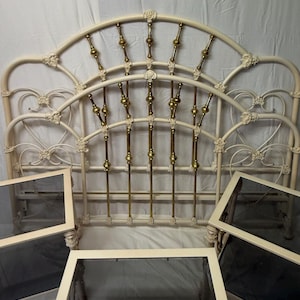 May include: White metal bed frame with gold accents and ornate details. The frame has a curved headboard and footboard.