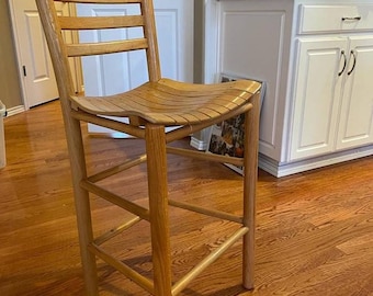 May include: A wooden bar stool with a slatted back and seat. The stool is made of natural wood and has a simple, rustic design.