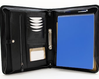 May include: Black leather zippered portfolio with a ring binder, a pen holder, and a blue notebook. The portfolio has multiple card slots and a clear plastic window for a business card.