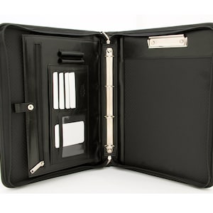 May include: Black leather zippered binder with a built-in clipboard, ring binder, and multiple pockets for cards and pens.