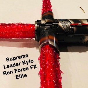 Op de afbeelding: Een rood lightsaber met een zwarte handgreep en de tekst "Supreme Leader Kylo Ren Force FX Elite".