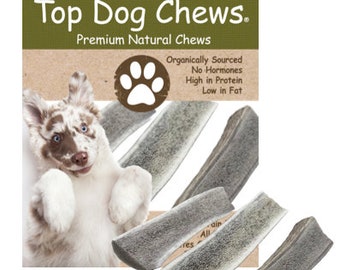 May include: A package of Top Dog Chews premium natural dog chews. The package features a cartoon dog paw print and text that reads "Organically Sourced, No Hormones, High in Protein, Low in Fat". The package includes four antler chews.