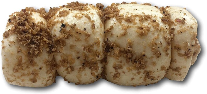 May include: A close-up of four white buns covered in a brown, crumbly topping. The buns are arranged in a row and appear to be soft and fluffy.