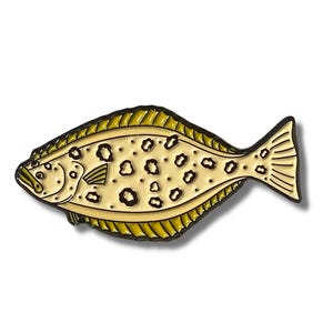 K&ouml;nnte beinhalten: Eine gelbe und braune Emaille-Anstecknadel mit einem Plattfisch mit schwarzen Flecken. Die Anstecknadel ist eine realistische Darstellung eines Flundern.