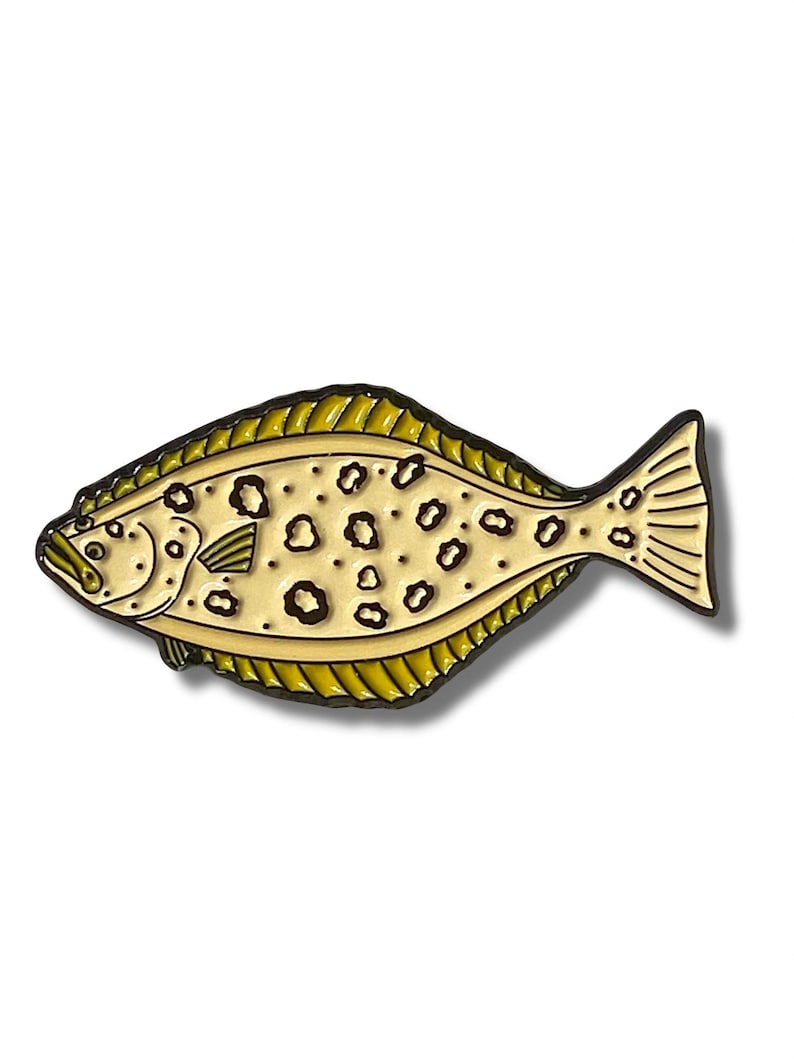 K&ouml;nnte beinhalten: Eine gelbe und braune Emaille-Anstecknadel mit einem Plattfisch mit schwarzen Flecken. Die Anstecknadel ist eine realistische Darstellung eines Flundern.