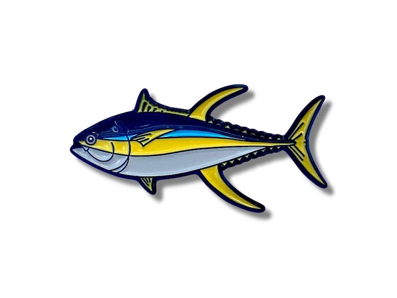K&ouml;nnte beinhalten: Eine Emaille-Anstecknadel mit einem Gelbflossen-Thunfisch mit blauen und gelben Details. Die Anstecknadel ist eine realistische Darstellung eines Thunfischs mit wei&szlig;em Bauch und einem blauen und gelben Streifen.
