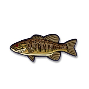 K&ouml;nnte beinhalten: Eine Emaille-Anstecknadel mit einem kleinen Barsch, braun und gr&uuml;n gef&auml;rbt, mit roten Augen.