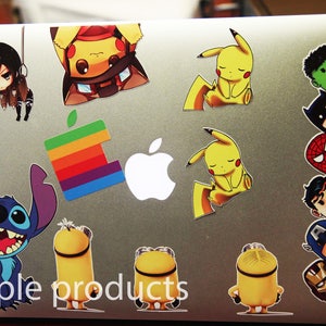May include: A laptop computer with various colorful stickers, including cartoon characters, a rainbow design, and an apple logo. The stickers are arranged in a random pattern on the silver laptop cover. The text "sample products" is printed on the bottom of the laptop.