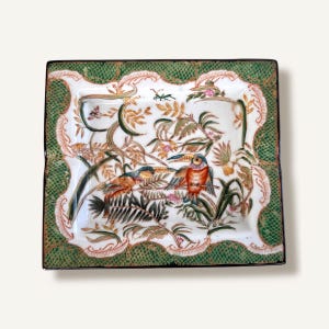 May include: Square ceramic decorative plate with a white center featuring a detailed illustration of birds perched on branches with leaves and flowers. The border is green with a scalloped edge and a black trim.