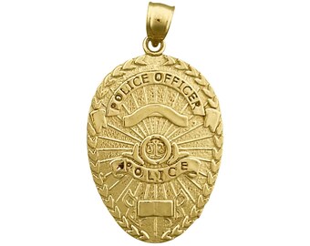 以下が含まれることがあります： ゴールドトーンの警察官バッジペンダント。楕円形のペンダントには、「POLICE OFFICER」と「POLICE」の文字が浮き彫りになっており、月桂樹の冠と太陽光線のデザインで囲まれています。上部にはベイルが付いています。