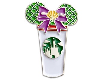 Può includere: Uno spillo in smalto verde e viola con una tazza Starbucks con un logo del castello Disney e un fiocco verde e viola con una conchiglia al centro. Il fiocco è a forma di orecchie di Topolino.