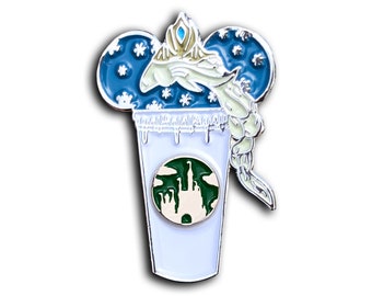 Può includere: Uno spillo in smalto bianco con un design a orecchie di Topolino blu e bianco. Le orecchie sono piene di fiocchi di neve e una figura bianca con una corona blu e una treccia bianca è all'interno delle orecchie. La figura tiene una tazza bianca con un logo Starbucks verde e un castello verde all'interno del logo. La tazza ha una glassa bianca che cola sui lati.