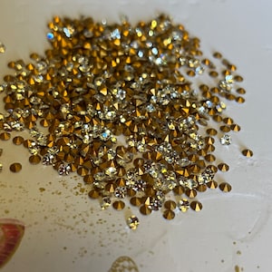 Könnte beinhalten: Ein Haufen goldener und klarer Strasssteine, perfekt zum Basteln und Dekorieren.