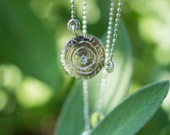 Necklace with compass medal, tiny diamond in the center