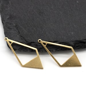 May include: Two gold-toned metal geometric shapes with a diamond-like design. The shapes are open and have a flat, solid bottom.