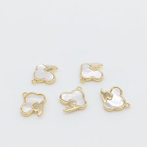 May include: Five gold-tone metal charms with a white shell inlay in the shape of a cloud with a lightning bolt design.