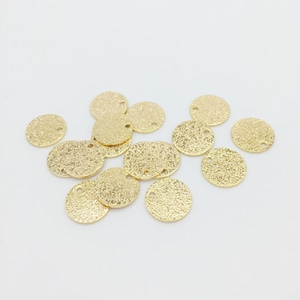 Könnte beinhalten: Eine Gruppe von 14 goldfarbenen Metall-Kreisanhängern mit einer strukturierten Oberfläche. Jeder Anhänger hat ein kleines Loch in der Mitte.