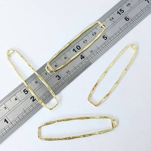 May include: Four gold-colored metal rectangular frames with a textured surface. The frames are of varying sizes and are measured against a ruler.