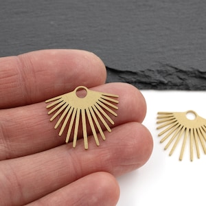 以下が含まれることがあります： ジュエリーに取り付けるための穴が上部に開いた、太陽の形をした金色の金属製イヤリングチャーム2個