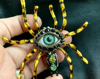 Broche de aranha pintado à mão com olho verde e strass.