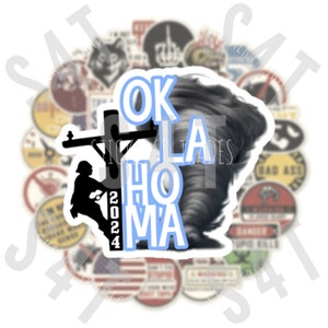 May include: A white sticker with a blue outline featuring a silhouette of a lineman climbing a utility pole with the text "OKLAHOMA" and the year "2024" in blue lettering. A tornado is depicted in the background.