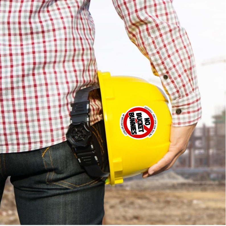 Puede incluir: Un casco amarillo con una pegatina roja y blanca que dice "NO BUCKET BUNNIES".
