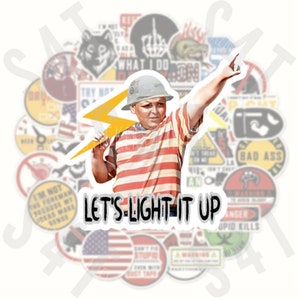 May include: A sticker featuring a cartoon illustration of a young boy wearing a hard hat and holding a lightning bolt. The boy is wearing a red and white striped shirt. The sticker has the text "Let's-Light It Up" in a white circle.