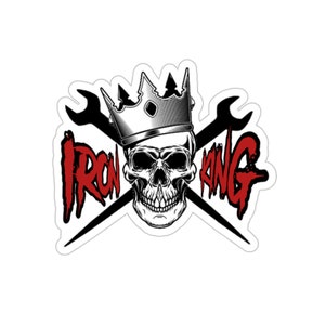 May include: A black and white illustration of a skull wearing a silver crown with two crossed wrenches behind it. The text "IRON KING" is written in red letters.