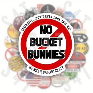 Puede incluir: Un c&iacute;rculo rojo con una l&iacute;nea diagonal que lo atraviesa, con el texto "NO BUCKET BUNNIES" en negro. Debajo del c&iacute;rculo est&aacute; el texto "MY WIFE IS BAT-SHIT CRAZY".