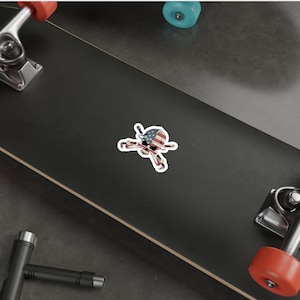 May include: A sticker featuring a skull wearing a hard hat with the American flag design. The skull is holding two crossed wrenches.