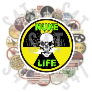 May include: A yellow and black circular sticker with a skull and crossbones graphic. The skull is green and has a lightning bolt through its mouth. The text "NUKE LIFE" is written in green dripping letters.