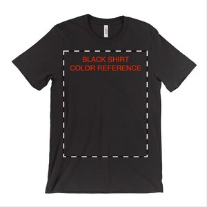 May include: A black t-shirt with a white dashed border around the center of the shirt. The text "BLACK SHIRT COLOR REFERENCE" is printed in red letters inside the border.