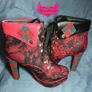 May include: A pair of red and black high-heeled boots with black lace detailing and a diamond pattern on the ankle cuffs. The boots have a chunky heel and a platform sole. The text "Funky Fairy Godmother" is visible in the background.