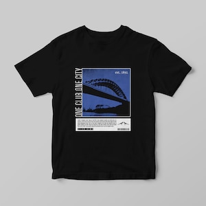 Peut inclure: T-shirt noir avec un motif bleu et blanc repr&eacute;sentant un pont et le texte "ONE CLUB ONE CITY" et "est. 1892". Le t-shirt comprend &eacute;galement du texte suppl&eacute;mentaire et un code-barres.