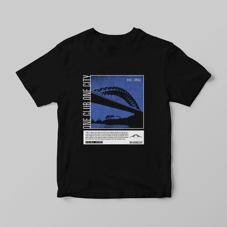 Peut inclure: T-shirt noir avec un motif bleu et blanc repr&eacute;sentant un pont et le texte "ONE CLUB ONE CITY" et "est. 1892". Le t-shirt comprend &eacute;galement du texte suppl&eacute;mentaire et un code-barres.