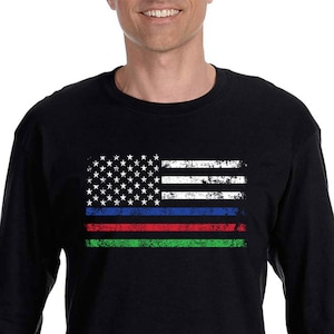 Może przedstawiać: Czarny T-shirt z długim rękawem z przetartym wzorem amerykańskiej flagi z cienkimi niebieskimi, czerwonymi i zielonymi paskami.