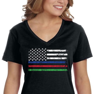 Może przedstawiać: Czarny t-shirt z dekoltem w kształcie litery V z przetartym wzorem amerykańskiej flagi z cienkimi niebieskimi, czerwonymi i zielonymi paskami.