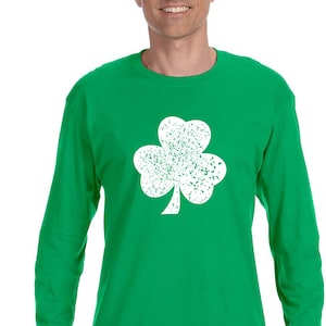 May include: A green long-sleeved t-shirt with a white distressed shamrock design.