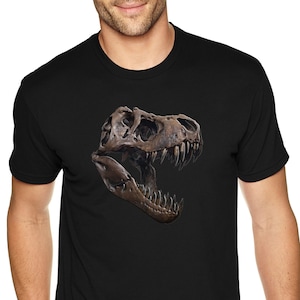 May include: A black t-shirt with a graphic print of a Tyrannosaurus Rex skull.