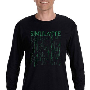 Può includere: Una maglietta nera a maniche lunghe con una stampa grafica verde della parola "SIMULATE" e un motivo a codice in stile matrix.