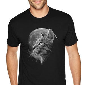May include: A black t-shirt with a graphic of a cat looking up at a full moon. The cat and moon are in shades of gray.