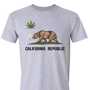 May include: A grey t-shirt with a graphic of the California state flag featuring a bear smoking a joint and a marijuana leaf. The text "CALIFORNIA REPUBLIC" is printed below the graphic.