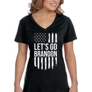 May include: Black V-neck t-shirt with a white distressed American flag design and the text "LET'S GO BRANDON".