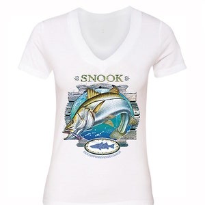 May include: White V-neck t-shirt with a graphic of a snook fish jumping out of the water. The graphic includes the words "Snook" and "Centropomus undecimalis".