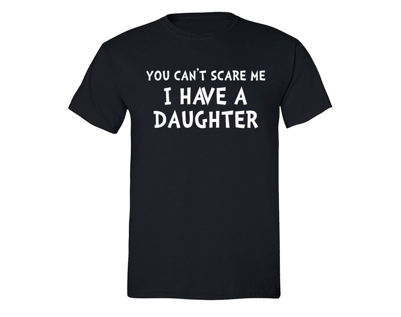 Puede incluir: Una camiseta azul marino con el texto blanco: "YOU CAN'T SCARE ME I HAVE A DAUGHTER". La camiseta tiene cuello redondo y probablemente est&aacute; hecha de algod&oacute;n. Una prenda casual para todos los d&iacute;as.