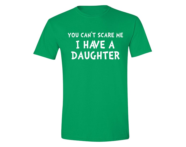 Puede incluir: Una camiseta verde con texto blanco que dice "YOU CAN'T SCARE ME I HAVE A DAUGHTER". La camiseta tiene mangas cortas y cuello redondo.
