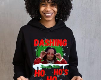 May include: Black hoodie with the text "Dashing" in red and green, featuring an image of a man wearing sunglasses. The phrase "Through these Ho's Ho Ho" is printed below the image in red and white.