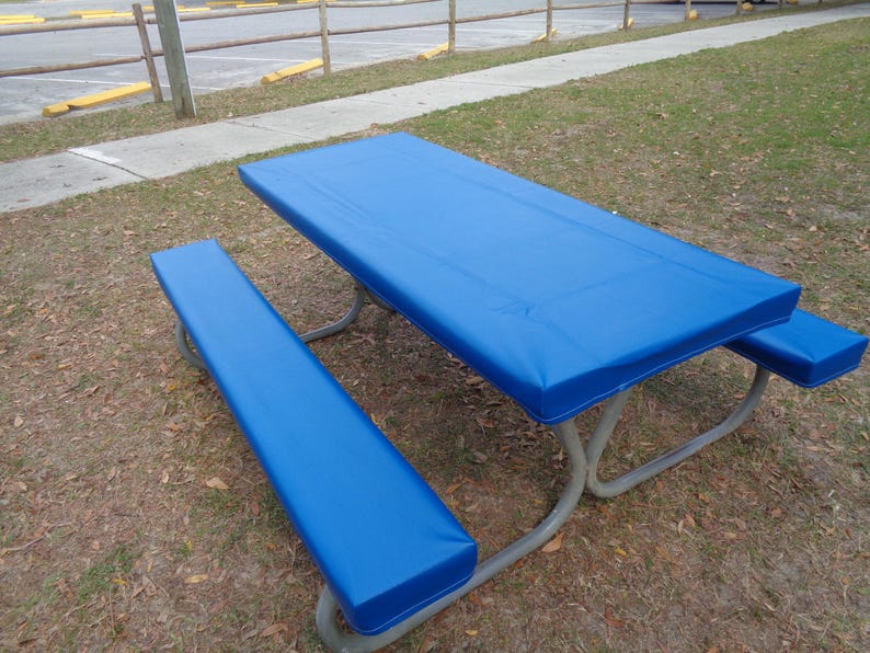 May include: A blue picnic table cover with a matching bench cover. The cover is made of a waterproof material and is designed to protect the table from the elements.