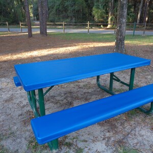 May include: A blue picnic table with a matching blue bench. The table and bench are made of metal with a green frame.
